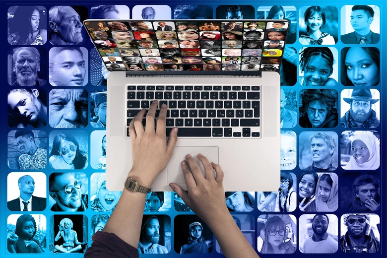 Laptop und im Hintergrund verschiedene Portraits von Menschen unterschiedlicher Herkunft.