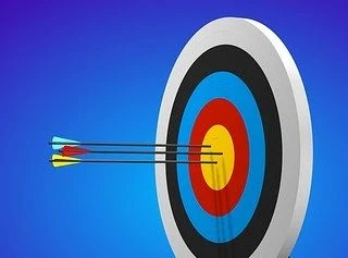 Zielscheibe mit Wurfpfeilen im Bullseye